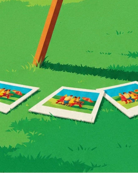 The 3 white-bordered photos lying in the grass at the foot of the tripod