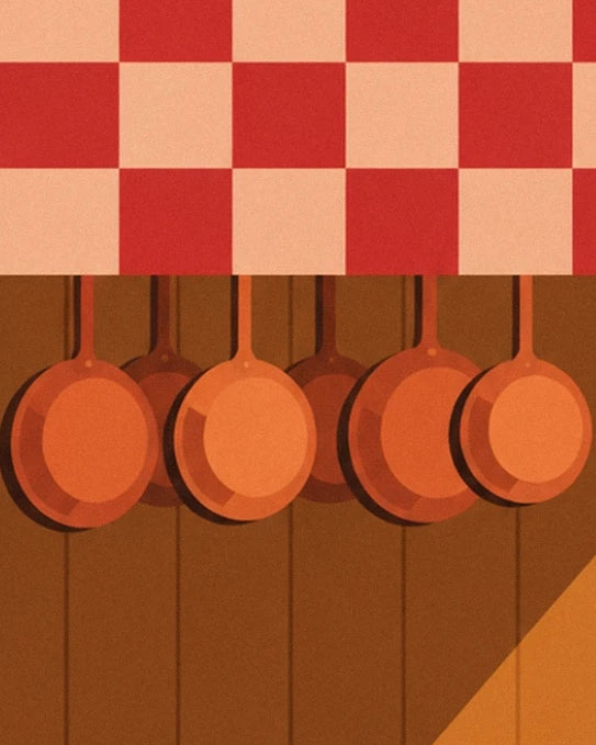 Copper pans hanging on the wooden wall beneath the checked tablecloth