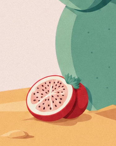 A prickly pear cut in 2 on the sand, with pink flesh and black seeds
