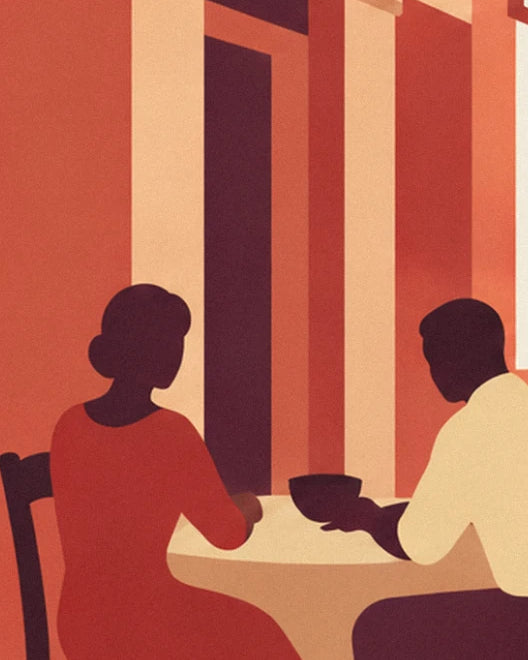 A couple seated at a table seen from behind, her in a red dress and him in a cream shirt, facing the columns
