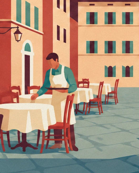 The waiter in a white apron between tables with tablecloths and red chairs in the square