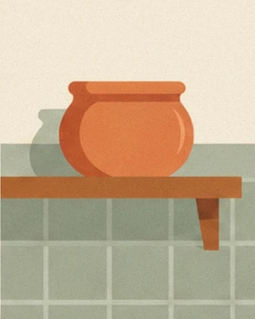 An orange terracotta pot on a wooden shelf in front of green tiles