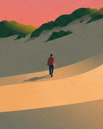 Un promeneur en veste rouge au pied des dunes ombragées de l’Espiguette