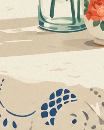 The cream tablecloth with blue patterns beneath the glass vase and its long shadow