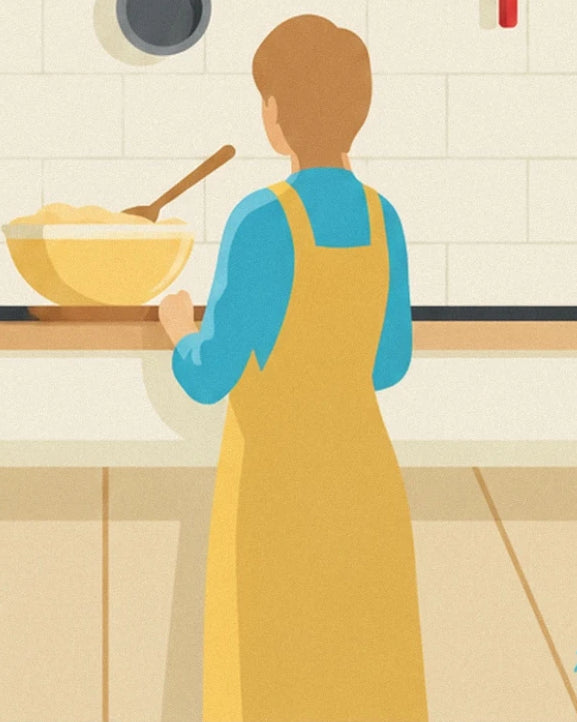 A figure seen from behind in a yellow apron, in front of a mixing bowl and wooden spoon