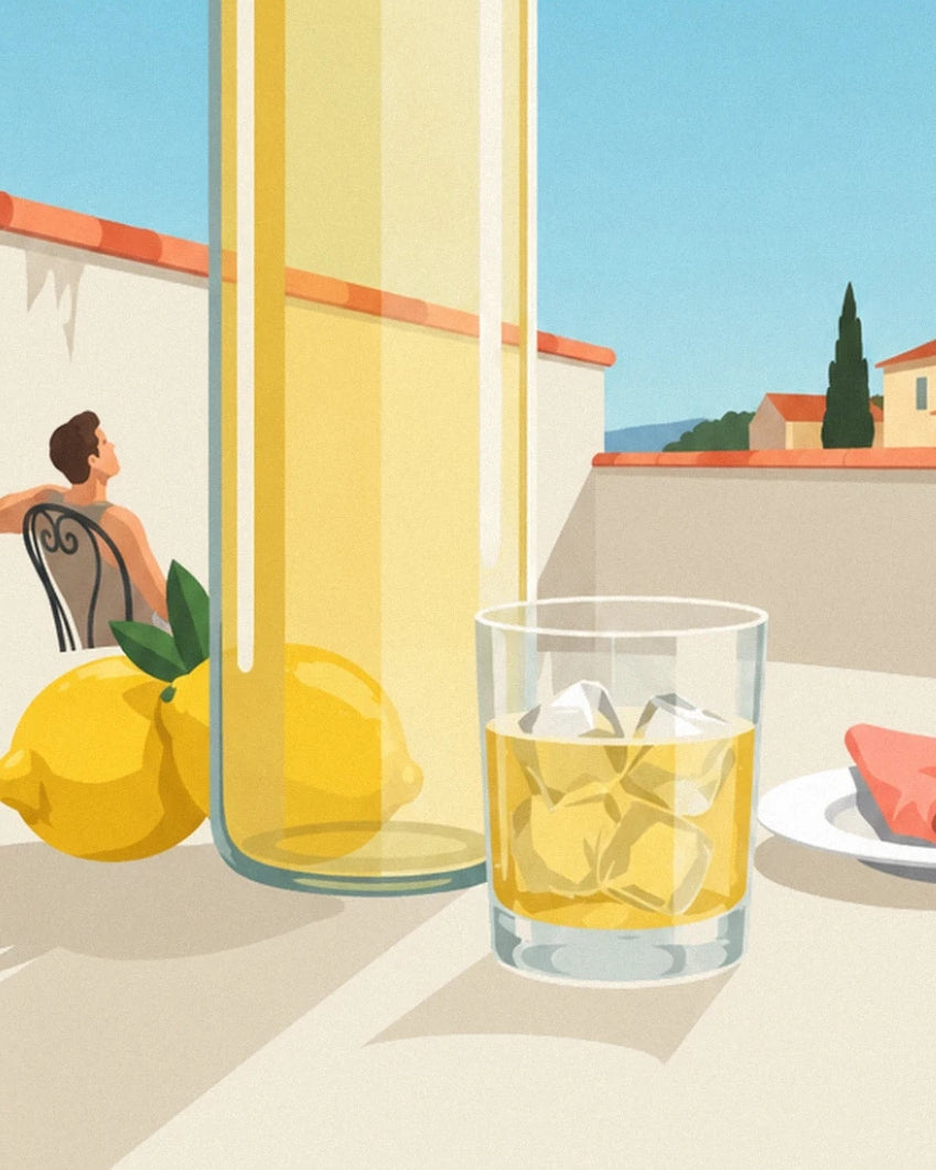 The bottle of lemonade, 2 lemons and a glass of ice cubes, with a man seated in the background