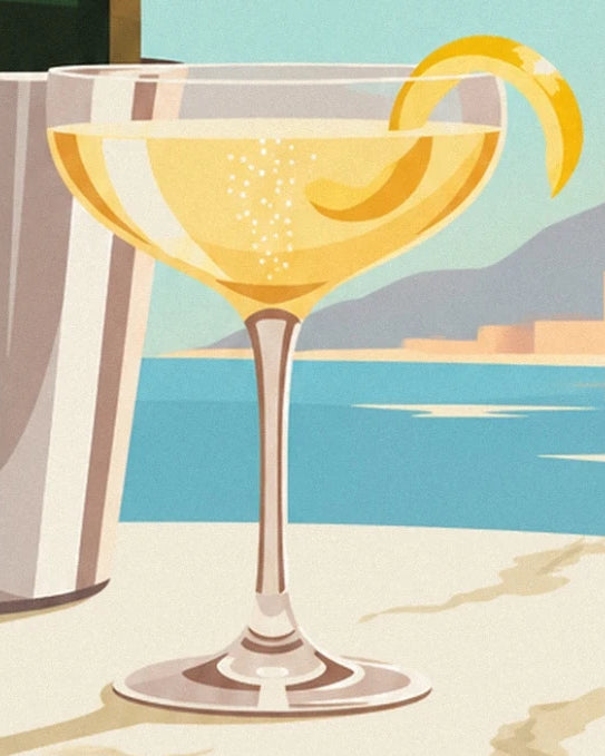 La coupe de cocktail doré et ses fines bulles, garnie d’un long zeste de citron