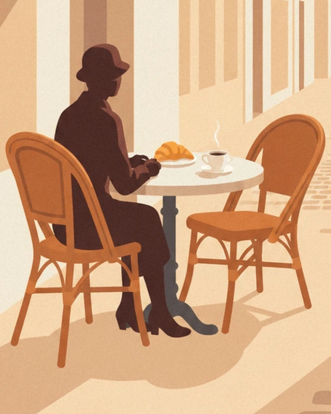 A figure in a hat with a steaming coffee and a croissant on the terrace