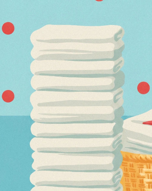 La haute pile de serviettes blanches bien pliées, près d'un panier d'osier, sur fond bleu à pois