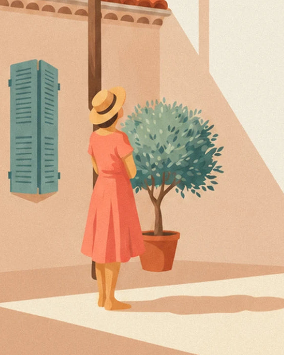 Femme en robe corail et chapeau de paille, de dos devant un olivier en pot et des volets bleu-vert