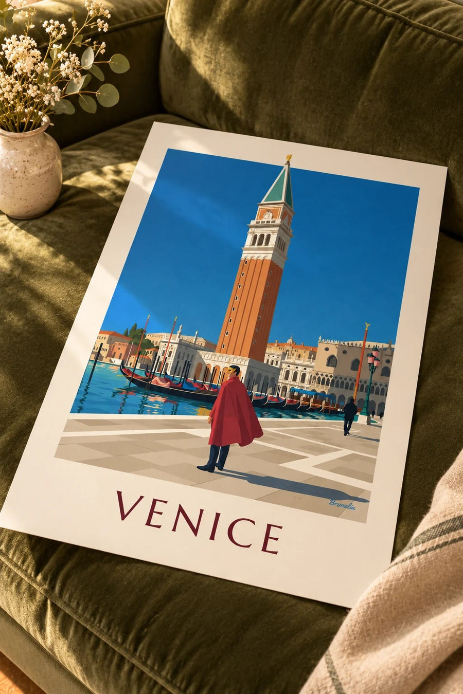 Masked man in red cape and St Mark’s Campanile poster: placed on a table