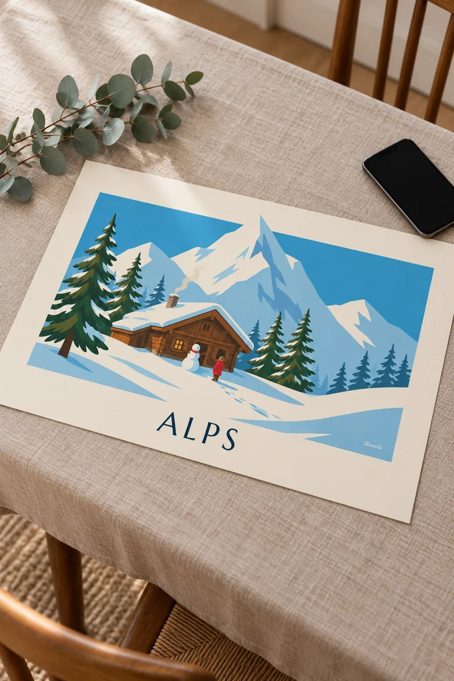 Snowy Alpine chalet and snowman poster: placed on a table