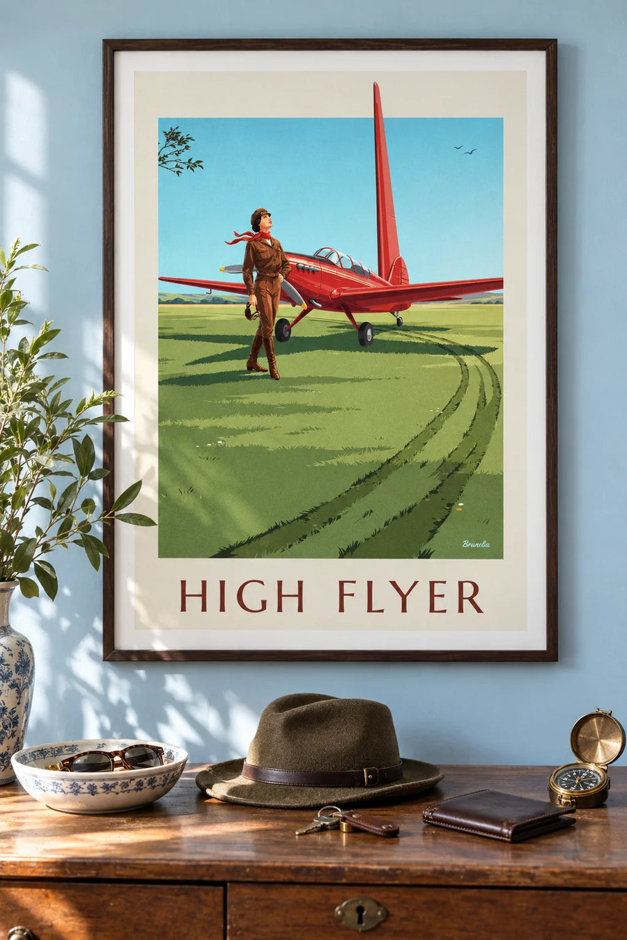 Poster of a female aviator and a red propeller plane on a grass runway: framed on the wall