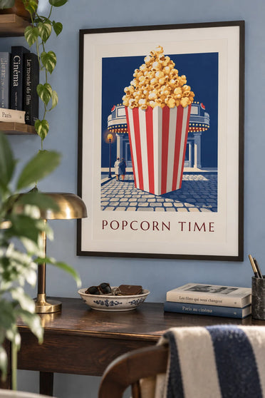 Hot red-and-white striped popcorn bucket in front of the cinema poster: framed on the wall